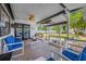 Relaxing covered patio with comfortable blue and white seating and a view of the landscaped backyard at 8444 8Th N Way, St Petersburg, FL 33702