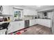 Bright kitchen with white cabinets, stainless steel dishwasher and granite countertops at 8444 8Th N Way, St Petersburg, FL 33702