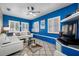 Living room featuring blue accent wall, modern furniture, plantation shutters, and tile flooring at 8444 8Th N Way, St Petersburg, FL 33702