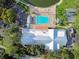 Overhead aerial view of the community pool, clubhouse, ample parking, and surrounding trees at 8531 Woodcrest Dr, Port Richey, FL 34668