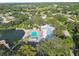 Community amenities include a pool, clubhouse, tennis court, lake and surrounding greenery at 8531 Woodcrest Dr, Port Richey, FL 34668