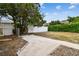 Fenced backyard with a paved path and a large tree, providing privacy and shade at 8531 Woodcrest Dr, Port Richey, FL 34668