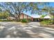 Exterior view of the Timber Oaks Clubhouse, featuring mature landscaping and convenient access at 8531 Woodcrest Dr, Port Richey, FL 34668
