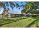 View of Timber Oaks Clubhouse featuring lush green lawn and mature trees at 8531 Woodcrest Dr, Port Richey, FL 34668