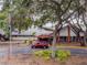 Exterior view of building entrance, enhanced by mature trees, landscaping, and clearly marked signage at 8531 Woodcrest Dr, Port Richey, FL 34668
