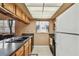 Compact kitchen features upper and lower cabinets, with a double basin sink and modern appliances at 8531 Woodcrest Dr, Port Richey, FL 34668