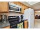 Well-equipped kitchen with range, microwave, cabinets, and tile flooring at 8531 Woodcrest Dr, Port Richey, FL 34668
