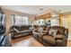 Inviting living room showcasing comfortable sofas, laminate flooring, and seamless access to the kitchen at 8531 Woodcrest Dr, Port Richey, FL 34668