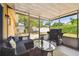Comfortable screened-in patio featuring outdoor seating, a glass table, and a grill at 8531 Woodcrest Dr, Port Richey, FL 34668