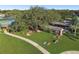 Overhead image of the outdoor recreation area, featuring benches and shaded seating beneath mature trees at 8531 Woodcrest Dr, Port Richey, FL 34668