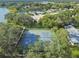 Overhead aerial view of the community tennis courts surrounded by lush greenery near the lake at 8531 Woodcrest Dr, Port Richey, FL 34668
