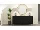 Hallway features a modern black sideboard, decorative lamps, a round mirror, and a green houseplant at 8582 Linked Dr, New Port Richey, FL 34655