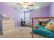 Bedroom with carpet and purple walls, decorated with toys at 9411 Lemon Drop Loop, Sun City Center, FL 33573