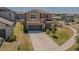 Inviting two-story house with a long driveway, a garage, and manicured front yard at 9411 Lemon Drop Loop, Sun City Center, FL 33573