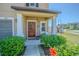Welcoming front porch with a wreath, a seating area, and lush greenery, creating an inviting entrance at 9411 Lemon Drop Loop, Sun City Center, FL 33573