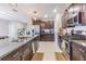 Spacious kitchen with a large island, granite countertops, stainless steel appliances, and dark cabinets at 9411 Lemon Drop Loop, Sun City Center, FL 33573