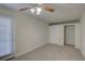 Bright bedroom with plush carpet, a ceiling fan, and ample closet space at 10319 Widgeon Way, New Port Richey, FL 34654