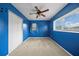Bedroom with blue walls, plush carpet, double-door closet, and bright windows at 10602 Camelia Dr, Port Richey, FL 34668