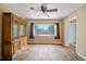 Bright living room featuring wood floors, a ceiling fan, and a large window at 10602 Camelia Dr, Port Richey, FL 34668