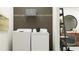 Bright laundry room features stacked white washer and dryer units and storage shelf with folded towels at 11106 E 65Th Ter, Palmetto, FL 34221
