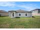 Backyard featuring green grass leading up to the patio and the home's exterior at 11257 Linden Depot Rd, San Antonio, FL 33576