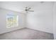 Bright bedroom with neutral walls, gray carpet, and a ceiling fan at 11257 Linden Depot Rd, San Antonio, FL 33576