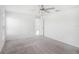 Spacious carpeted bedroom featuring a ceiling fan and a view into the hallway at 11257 Linden Depot Rd, San Antonio, FL 33576