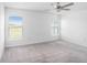 Bright bedroom with neutral carpet, a ceiling fan, and views of the outdoors from two windows at 11257 Linden Depot Rd, San Antonio, FL 33576