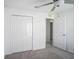 Bright bedroom with gray carpet, ceiling fan, closet, and easy access at 11257 Linden Depot Rd, San Antonio, FL 33576