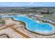 Aerial view of neighborhood amenities, including a large lagoon and recreational areas with surrounding residential areas at 11257 Linden Depot Rd, San Antonio, FL 33576