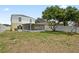 Large backyard featuring a screened-in patio and mature trees providing shade at 11323 Ivy Flower Loop, Riverview, FL 33578