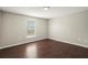 Bedroom with wood-look floors, neutral paint, and natural light from the window at 11323 Ivy Flower Loop, Riverview, FL 33578