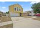 Bright yellow two-story home with a two car garage, black door, and well-maintained lawn at 11323 Ivy Flower Loop, Riverview, FL 33578