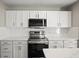Bright kitchen with stainless steel appliances, white cabinets and subway tile backsplash at 11323 Ivy Flower Loop, Riverview, FL 33578
