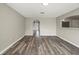 Open-concept living room with wood-look floors flowing seamlessly into the kitchen at 11323 Ivy Flower Loop, Riverview, FL 33578
