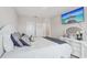 Stylish bedroom featuring a white bed frame, decorative pillows, and a mounted TV, perfect for relaxation and entertainment at 13055 Willow Grove Dr, Riverview, FL 33579