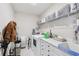 Functional laundry room with modern appliances, ample counter space, and built-in storage shelves at 13055 Willow Grove Dr, Riverview, FL 33579