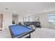 Bright and airy living room featuring a pool table, cozy seating, and plenty of natural light at 13055 Willow Grove Dr, Riverview, FL 33579