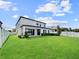 Expansive backyard with lush green grass, white picket fence, and view of the two-story house at 13130 Monach Isles Dr, Riverview, FL 33579