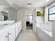 Elegant bathroom with double vanity, a soaking tub, and view to Main Bedroom suite at 13130 Monach Isles Dr, Riverview, FL 33579