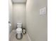 Small, minimalist half-bathroom with a toilet, trash can, and a light switch on the wall at 13130 Monach Isles Dr, Riverview, FL 33579
