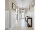 Inviting foyer boasts neutral walls, white wainscoting, tile floors, stylish console table, and decorative wall art at 13130 Monach Isles Dr, Riverview, FL 33579