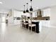 Beautiful kitchen featuring white cabinets, dark island with seating, modern pendant lighting, and stainless steel appliances at 13130 Monach Isles Dr, Riverview, FL 33579