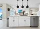 Bright kitchen with a center island, white cabinetry, stainless steel appliances, and open floor plan connects to the living area at 13130 Monach Isles Dr, Riverview, FL 33579