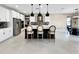 Bright kitchen featuring white cabinets, center island, modern pendant lighting, stainless steel appliances, and stylish barstools at 13130 Monach Isles Dr, Riverview, FL 33579