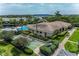 Aerial view featuring a community pool, clubhouse, and shuffleboard court surrounded by lush greenery at 1316 Pasadena S Ave # 303, South Pasadena, FL 33707