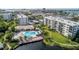 Aerial view of community featuring a pool and clubhouse with palm trees and waterfront access at 1316 Pasadena S Ave # 303, South Pasadena, FL 33707