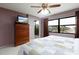 Bright bedroom featuring a ceiling fan, balcony access, and large windows providing ample natural light at 1316 Pasadena S Ave # 303, South Pasadena, FL 33707