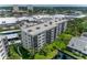 Aerial view of condo building featuring screened in balconies, well manicured lawn, and waterfront views at 1316 Pasadena S Ave # 303, South Pasadena, FL 33707