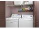 Convenient laundry room equipped with washer, dryer, and shelving at 1316 Pasadena S Ave # 303, South Pasadena, FL 33707